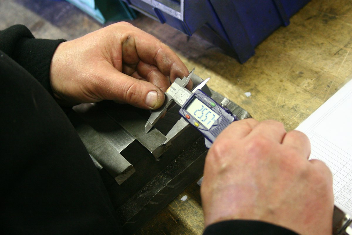 Digital caliper checking a machined step on a finished part
